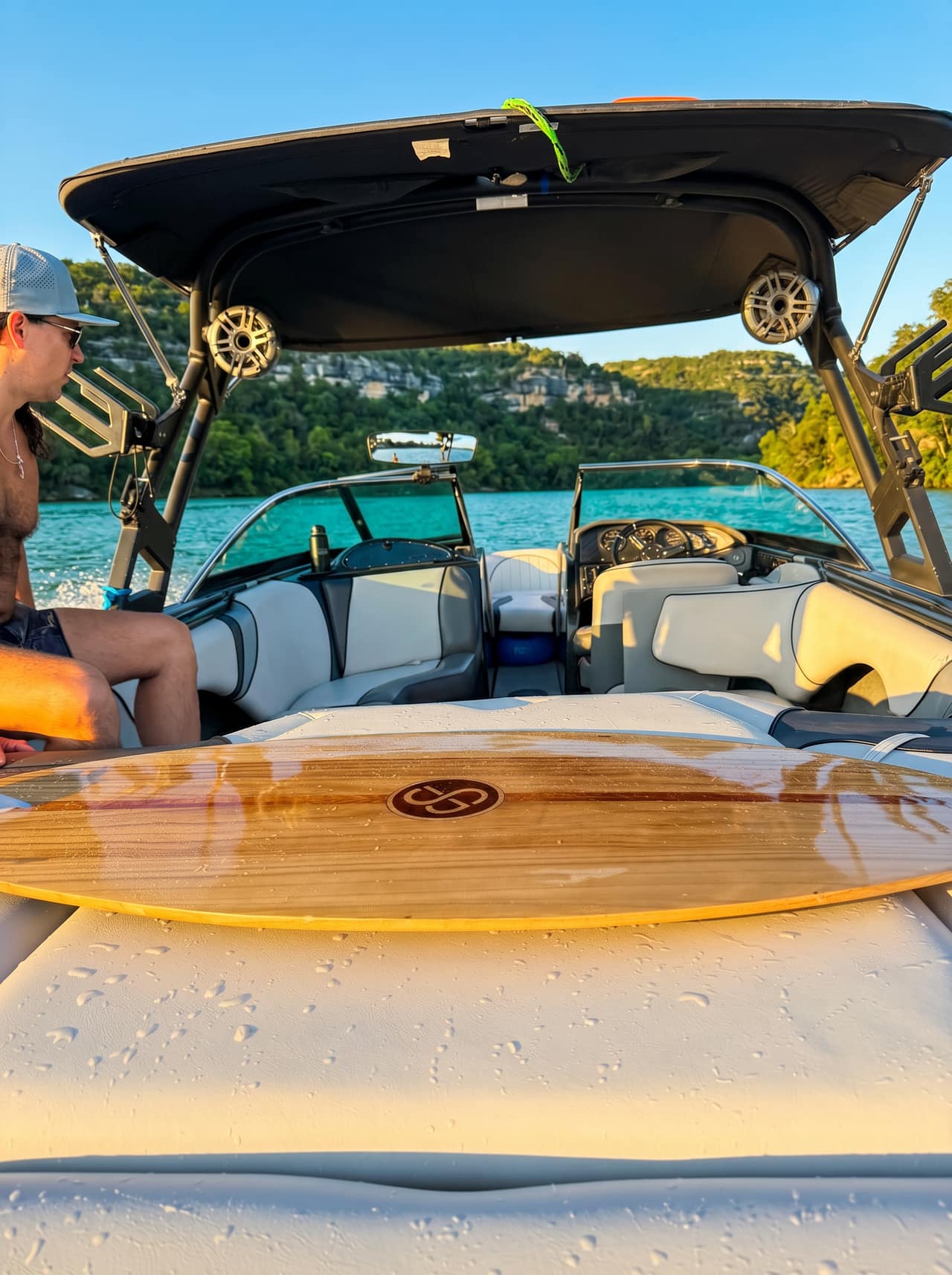 Sanger V237 SX wakesurf boat carving a clean wake on Lake Austin at golden hour
